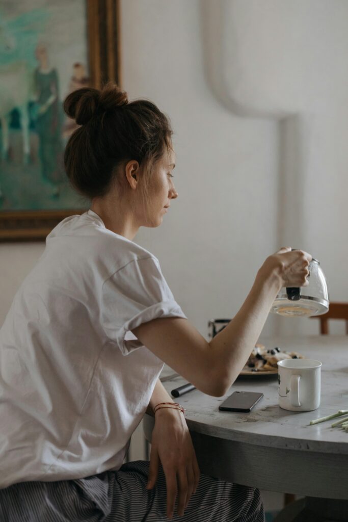 Woman sitting alone at home looking distant, reflecting the invisible mental load that never fully switches off