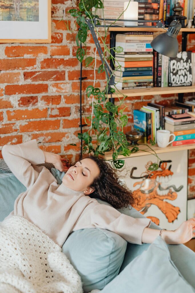 A person resting at home but still appearing mentally occupied, representing the persistent weight of mental load